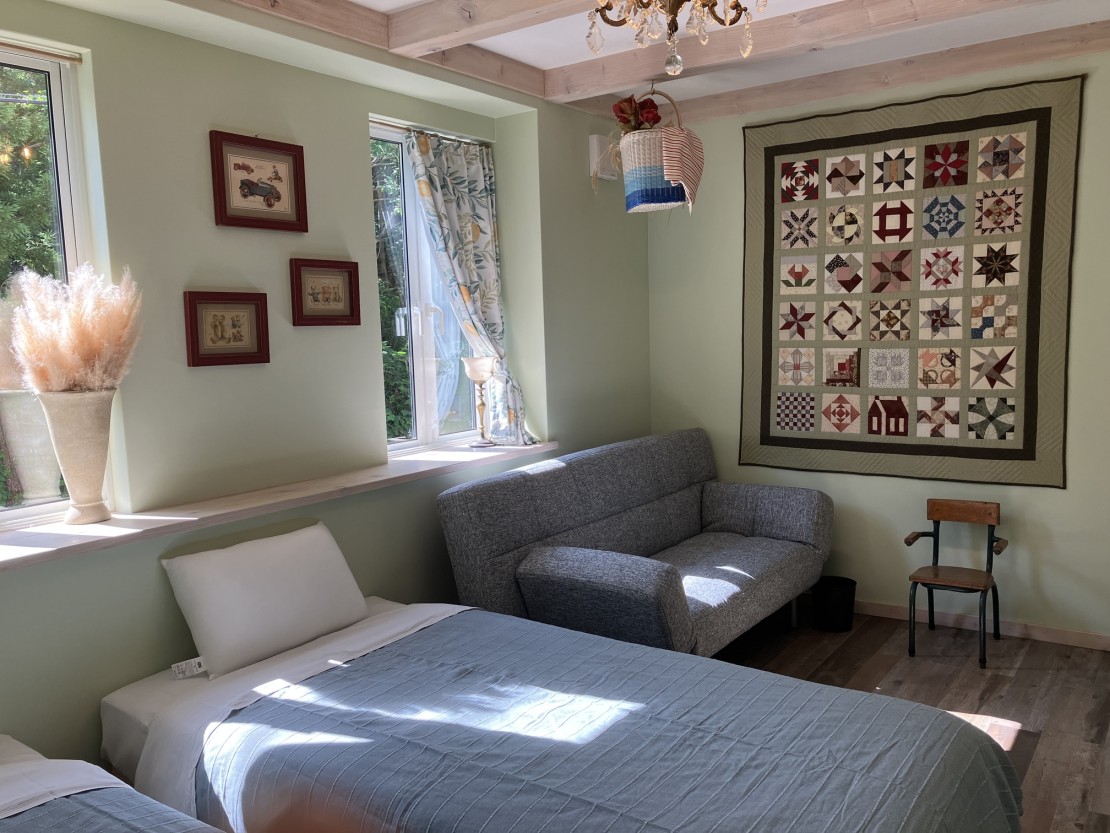 コテージハーベスト｜石川県・輪島・能登｜寝室A　おばあちゃん手作りのパッチワークキルト　ソファーがエキストラベッドになります。
